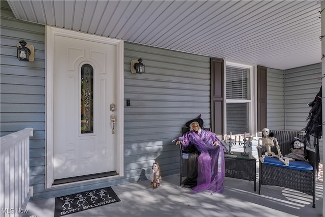 view of exterior entry featuring covered porch