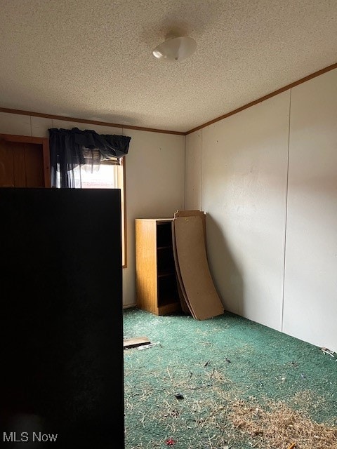 unfurnished room featuring crown molding, carpet floors, and a textured ceiling