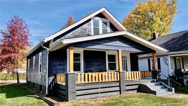 bungalow-style house with covered porch and a front lawn