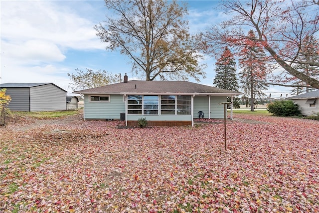 rear view of house featuring a shed