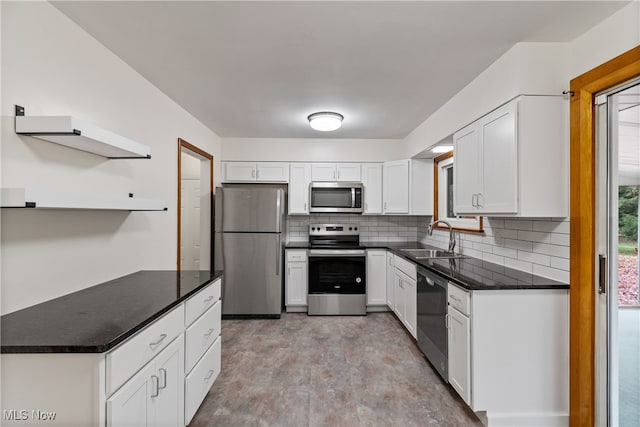 kitchen with appliances with stainless steel finishes, white cabinets, a healthy amount of sunlight, and sink