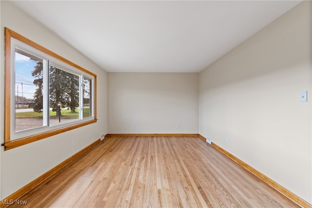 empty room with light hardwood / wood-style flooring and a wealth of natural light