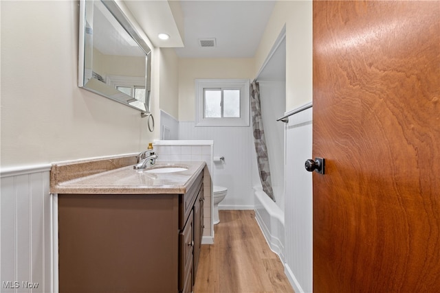 full bathroom with vanity, shower / bath combo, wood-type flooring, and toilet