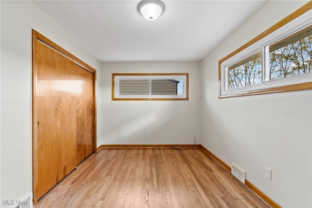 unfurnished bedroom featuring a closet and light hardwood / wood-style flooring