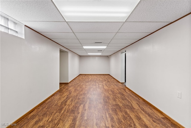 basement with a drop ceiling and hardwood / wood-style floors