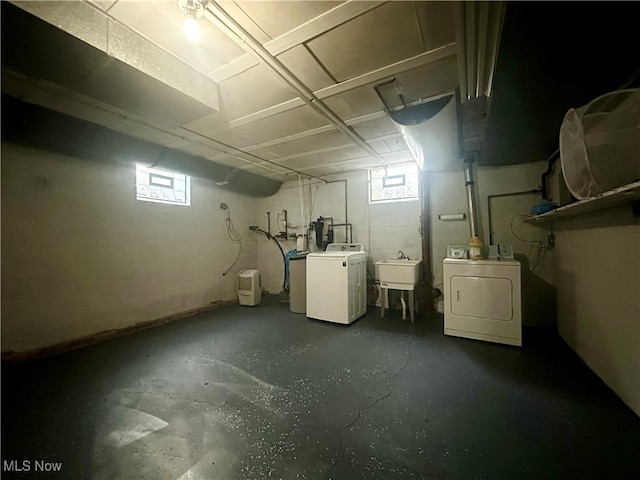 basement featuring independent washer and dryer, sink, and plenty of natural light