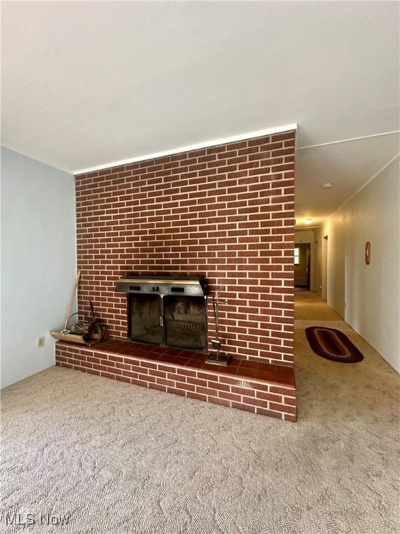 unfurnished living room with carpet floors and a fireplace