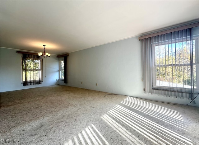 spare room with a notable chandelier and carpet