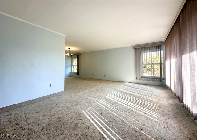 carpeted spare room with an inviting chandelier and wood walls