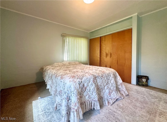 bedroom featuring a closet, lofted ceiling, carpet, and crown molding