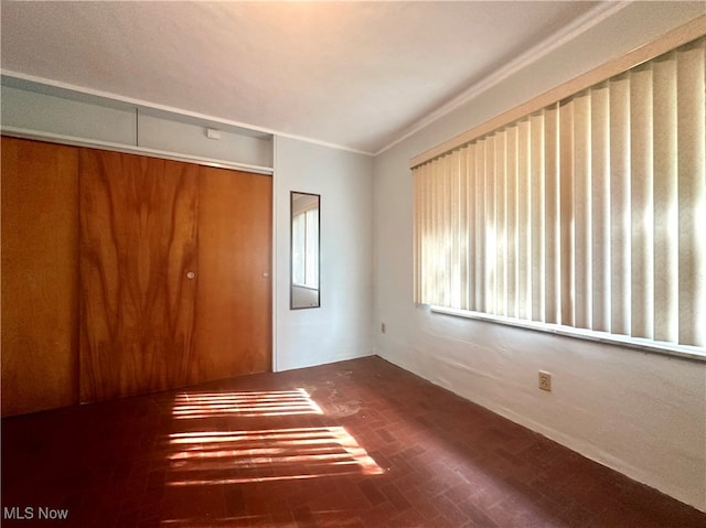 unfurnished bedroom with a closet and ornamental molding