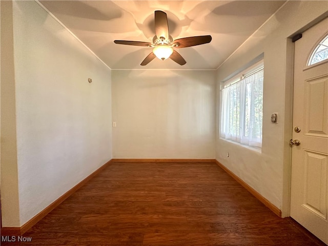 empty room featuring dark wood-type flooring, ceiling fan, and plenty of natural light