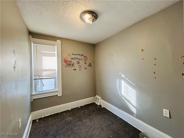 spare room with a textured ceiling and carpet floors