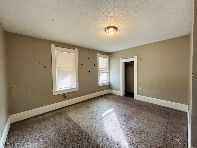 unfurnished bedroom featuring a textured ceiling and carpet floors