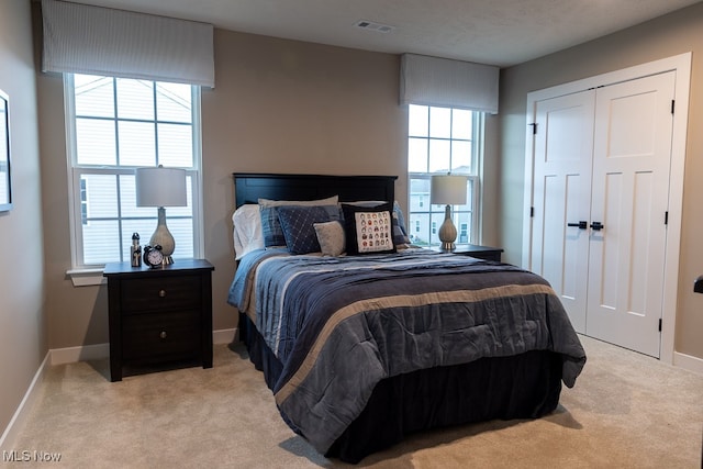 bedroom featuring a closet, a textured ceiling, and light colored carpet