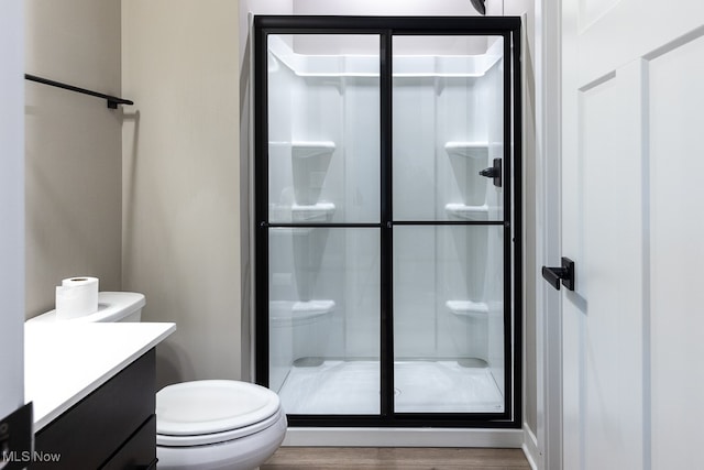 bathroom with vanity, walk in shower, toilet, and wood-type flooring