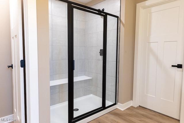 bathroom with hardwood / wood-style floors and walk in shower