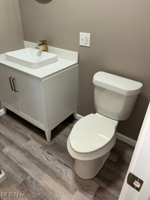 bathroom featuring vanity, hardwood / wood-style flooring, and toilet