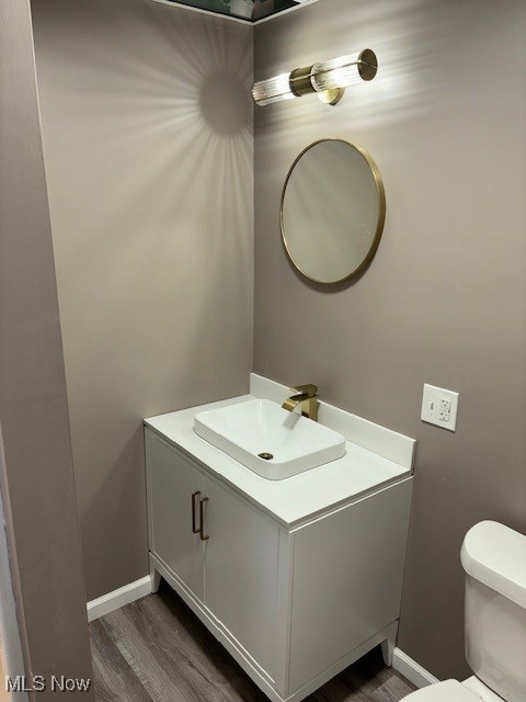 bathroom with vanity, toilet, and wood-type flooring