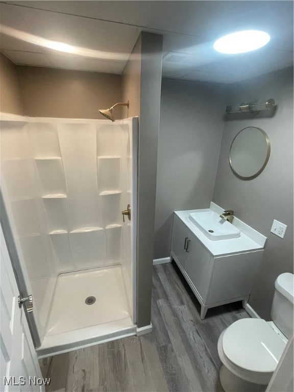 bathroom with vanity, hardwood / wood-style flooring, toilet, and walk in shower