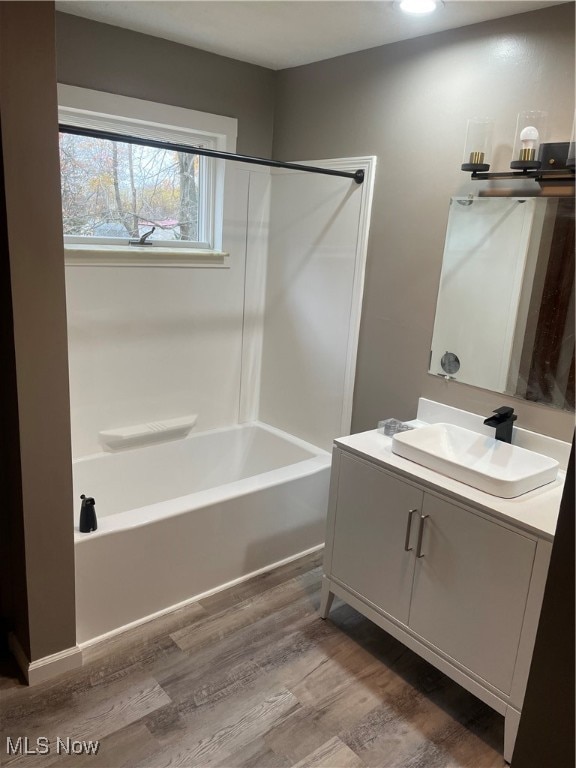 bathroom with vanity, hardwood / wood-style floors, and  shower combination