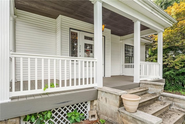 view of exterior entry featuring covered porch