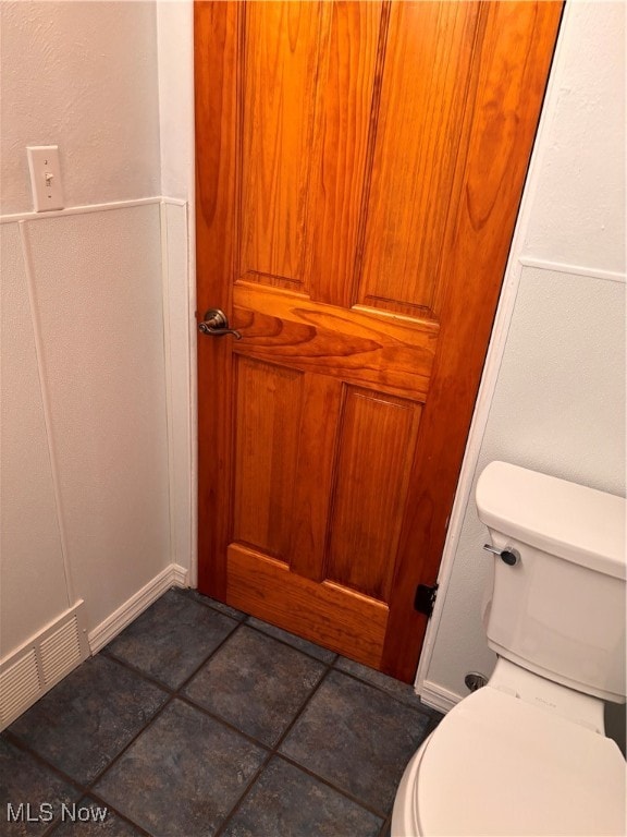 bathroom with toilet and tile patterned flooring