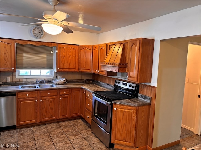 kitchen with sink, backsplash, ceiling fan, stainless steel appliances, and premium range hood