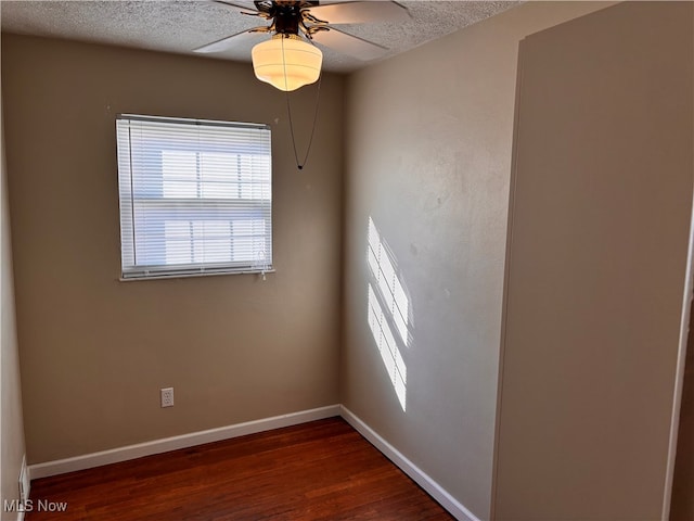 spare room featuring dark hardwood / wood-style floors, a textured ceiling, and ceiling fan