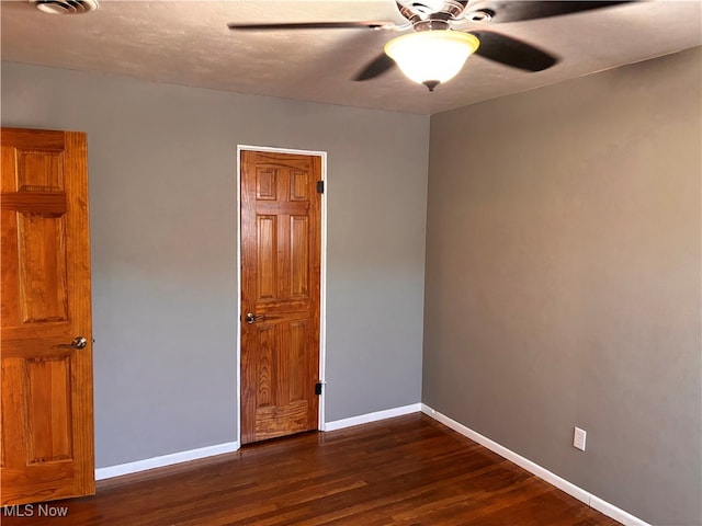 spare room with ceiling fan and dark hardwood / wood-style flooring