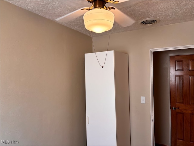 interior space with ceiling fan and a textured ceiling