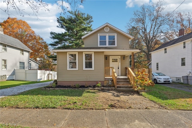 bungalow featuring a porch and a front lawn