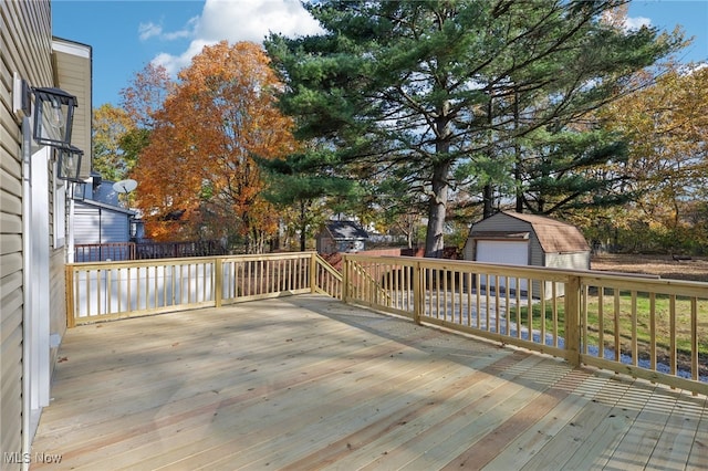 wooden deck featuring a garage and an outdoor structure