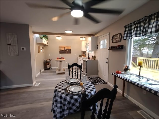 dining space featuring hardwood / wood-style flooring, ceiling fan, and sink