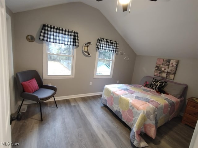 bedroom featuring hardwood / wood-style flooring, ceiling fan, vaulted ceiling, and multiple windows