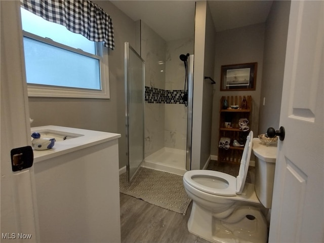 bathroom with hardwood / wood-style floors, vanity, an enclosed shower, and toilet