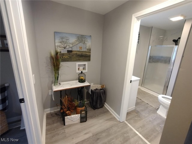 bathroom featuring hardwood / wood-style flooring, toilet, and an enclosed shower