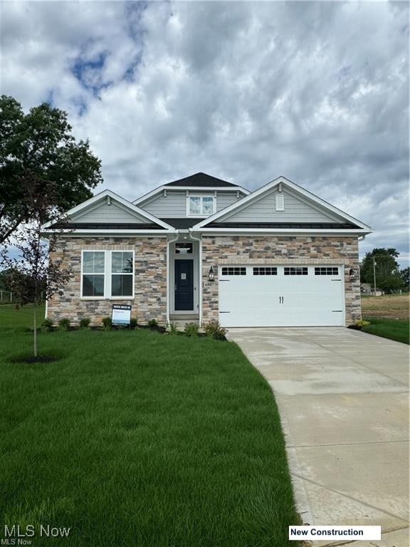 craftsman-style home with a garage and a front lawn