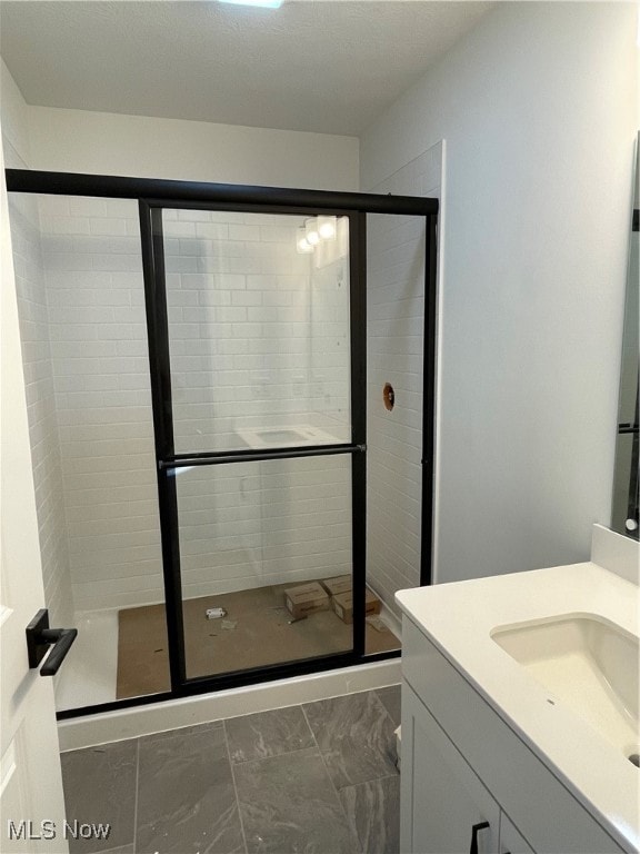 bathroom with vanity and a shower with door