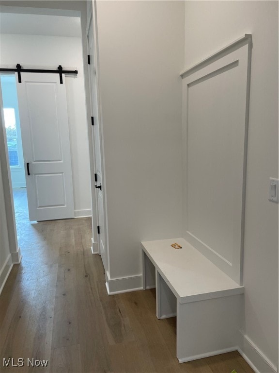 mudroom with a barn door and light hardwood / wood-style floors