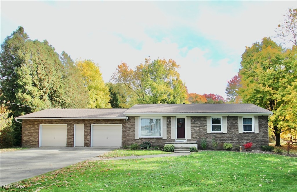 single story home featuring a front yard and a garage