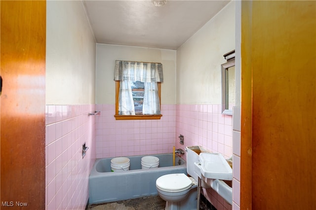 bathroom featuring a tub, tile walls, and toilet