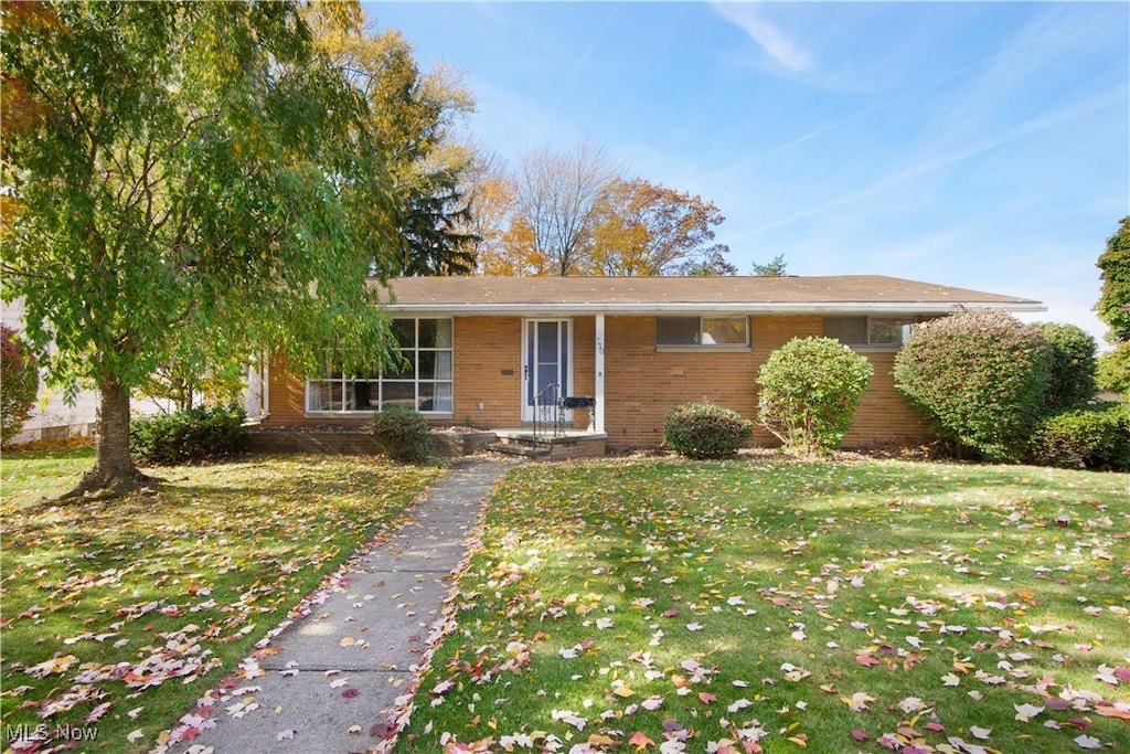 single story home featuring a front lawn