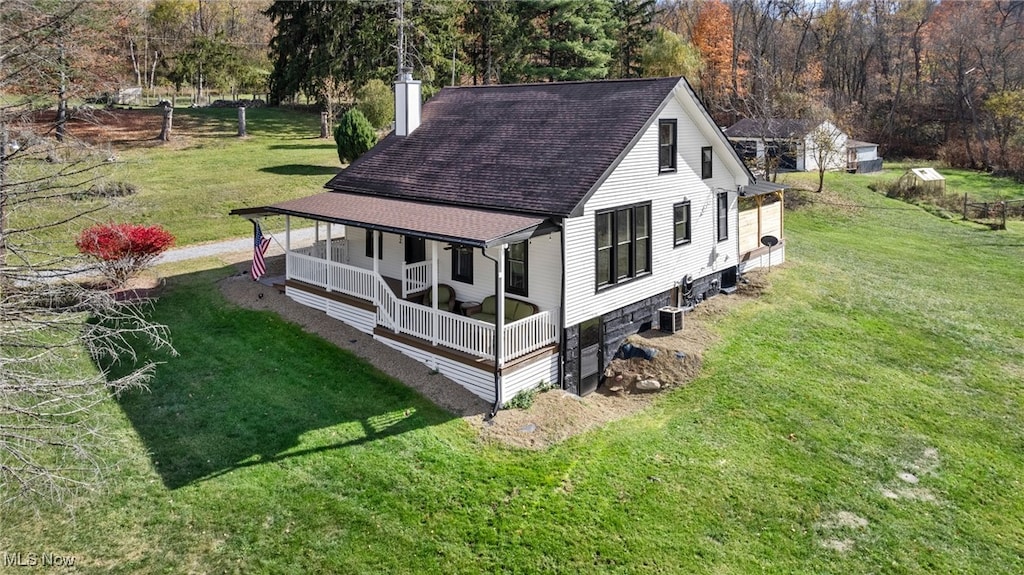 view of side of home featuring covered porch and a lawn