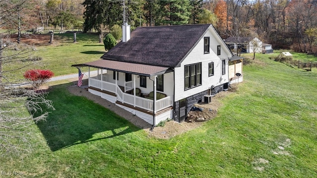 view of side of home featuring covered porch and a lawn