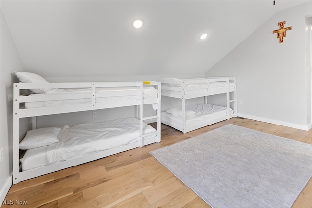 bedroom featuring hardwood / wood-style floors and vaulted ceiling