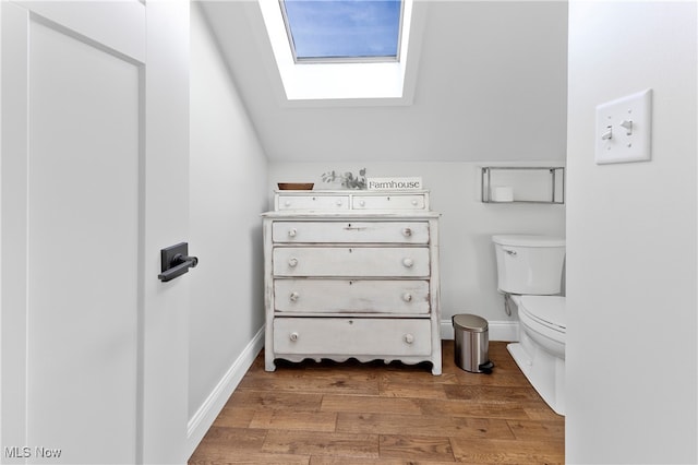 bathroom featuring vanity, toilet, vaulted ceiling, and hardwood / wood-style floors