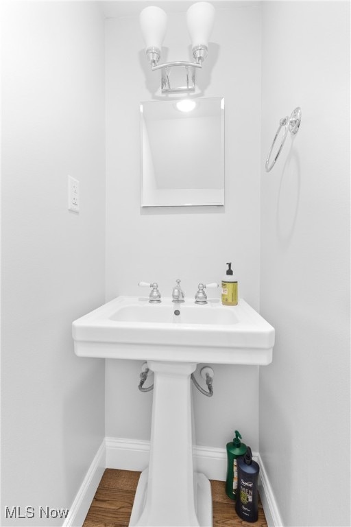 bathroom featuring wood-type flooring and an inviting chandelier