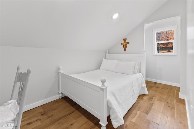 bedroom with lofted ceiling and hardwood / wood-style flooring