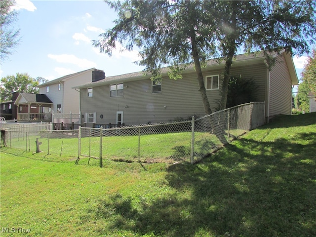 rear view of house featuring a yard